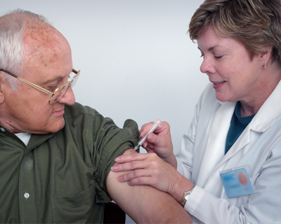 physician giving a shot on a patients left arm