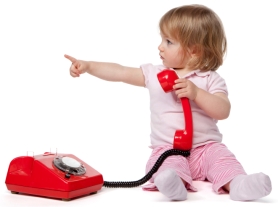 Child holding bright red phone and pointing to the left
