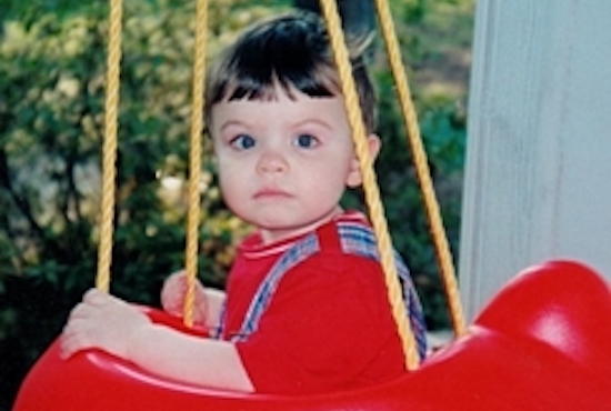 toddler in red plastic swing car