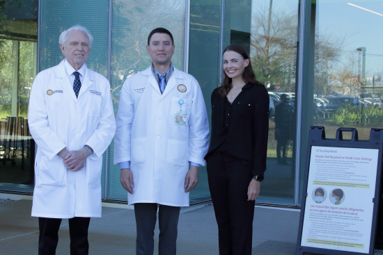 dr. michael rafii in an outpatient office holding a brain model across from two down syndrome patients